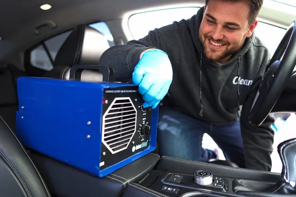 CleanWorx auto detailer operating an OdorStop ozone generator inside a vehicle interior for odor removal in Basking Ridge, NJ