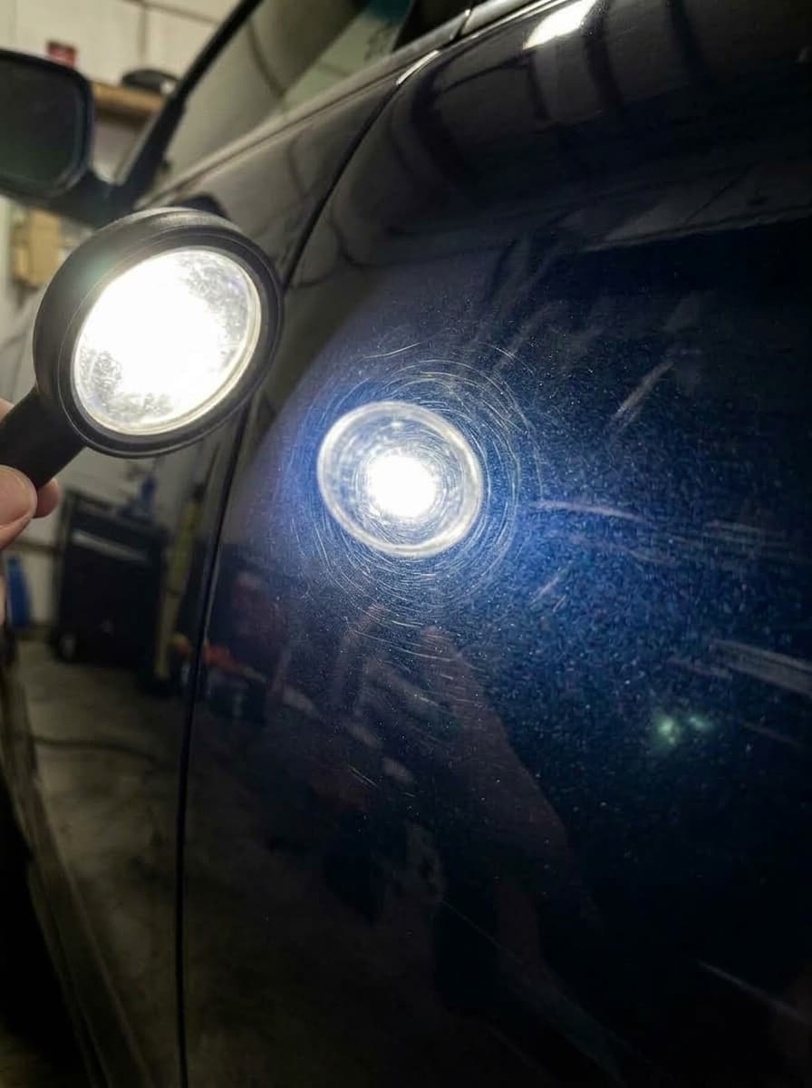 Vehicle clear coat with circular swirl marks and spiderweb scratches before correction